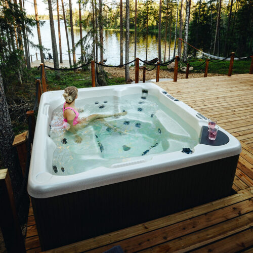 Woman in a hot tub beside a beautiful, Arctic lake in Lapland, Finland