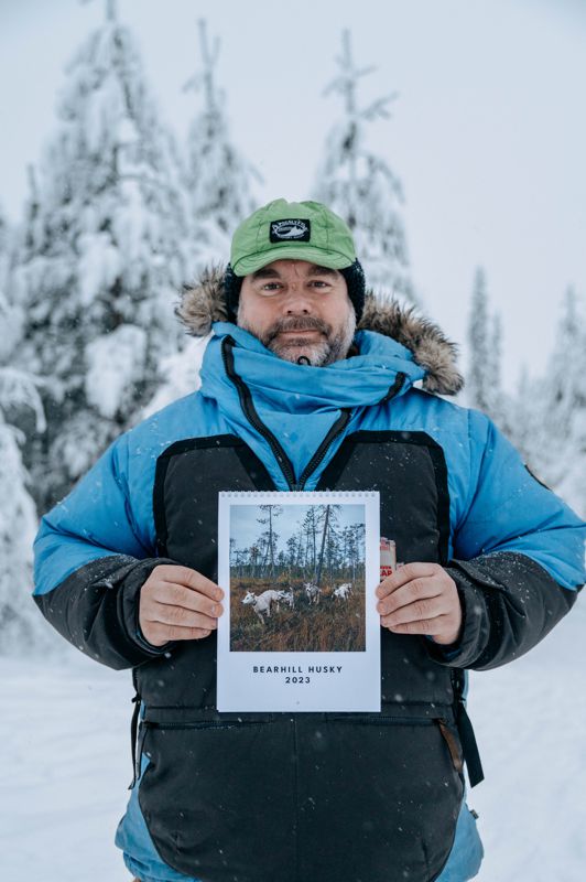 Bearhill Husky 2023 Calendar Owner Valentijn Beets holding calendar in Finnish wilderness