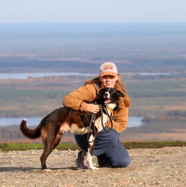 Jenna and her dog Peikko in front of a nice landscape view